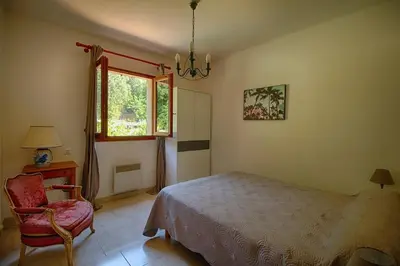 a bedroom with a bed and a chair and a window at VILLA 200 m de la plage La Liscia TIUCCIA in Casaglione