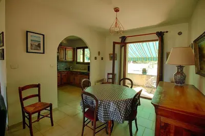 a kitchen and dining room with a table and chairs at VILLA 200 m de la plage La Liscia TIUCCIA in Casaglione