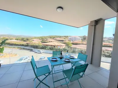 a dining room with a table and chairs on a balcony at Appartement 2 pièces Les Jardins de Livia 1 PORTICCIO in Porticcio