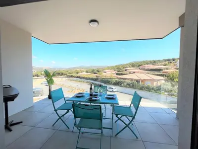 a dining room with a table and chairs and a large window at Appartement 2 pièces Les Jardins de Livia 1 PORTICCIO in Porticcio