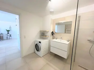 a bathroom with a washing machine and a sink at Appartement 2 pièces Les Jardins de Livia 1 PORTICCIO in Porticcio