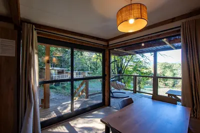 a living room with a table and a large window at BAVELLA VISTA in Zonza