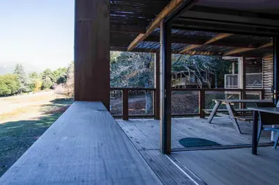 a screened porch with a table and a view at BAVELLA VISTA in Zonza