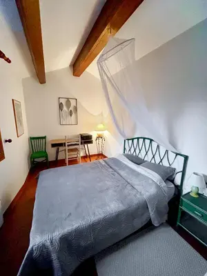a bedroom with a large bed and a table at 5 Min de la Plage - T4 avec Piscine & Tennis in Propriano