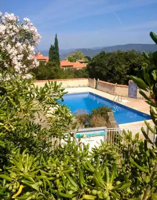 a large swimming pool in a yard with trees at 5 Min de la Plage - T4 avec Piscine & Tennis in Propriano