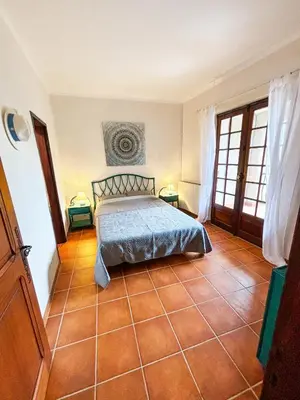 a bedroom with a bed and a tiled floor at 5 Min de la Plage - T4 avec Piscine & Tennis in Propriano