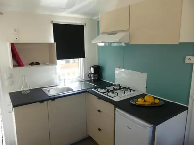 a small kitchen with a plate of fruit on the counter at Camping Rondinara in Bonifacio