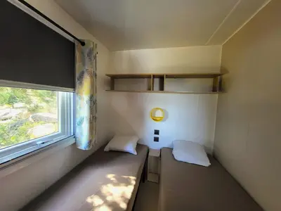 a small room with two beds and a window at Camping Rondinara in Bonifacio