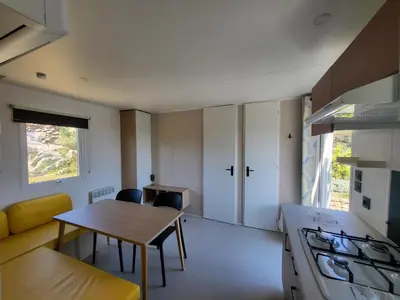 a kitchen and dining room with a table and a stove at Camping Rondinara in Bonifacio