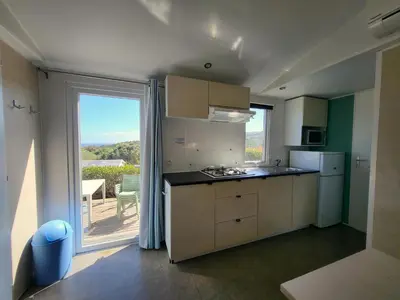 a kitchen with a counter and a large window at Camping Rondinara in Bonifacio