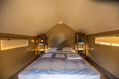 a small bedroom with two beds in a tent at Camping Rondinara in Bonifacio