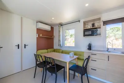 a kitchen and dining room with a table and chairs at Camping Rondinara in Bonifacio