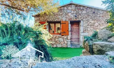 a stone house with a door in a yard at Location Casa Di Lesia à Sotta / Porto-Vecchio in Sotta