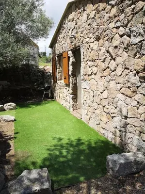 a stone building with a yard with green grass at Location Casa Di Lesia à Sotta / Porto-Vecchio in Sotta