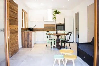 a living room with a table and chairs and a kitchen at Location Casa Di Lesia à Sotta / Porto-Vecchio in Sotta