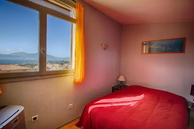 a bedroom with a red bed and a window at Villa Terra Bella 2 PORTICCIO in Porticcio