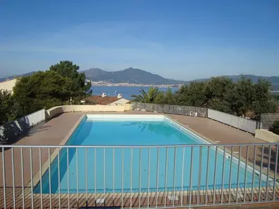a large blue swimming pool next to a fence at Villa Terra Bella 2 PORTICCIO in Porticcio