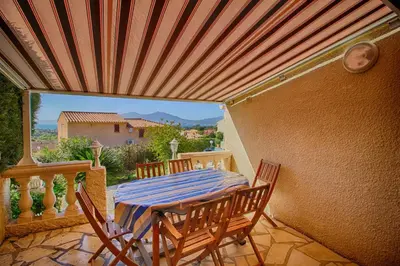 a patio with a table and chairs on a balcony at Villa Terra Bella 2 PORTICCIO in Porticcio