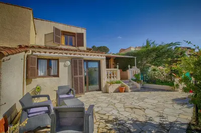 a house with a patio with chairs and a building at Villa Terra Bella 2 PORTICCIO in Porticcio