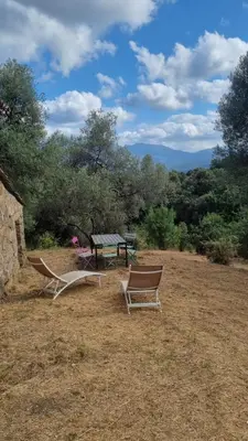 a picnic table and two chairs in a field at Langhjuledda in Grosseto-Prugna