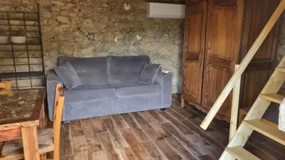 a living room with a couch and a wooden floor at Langhjuledda in Grosseto-Prugna