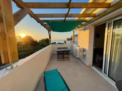 a patio with a table and chairs on a balcony at App. 2 p design zen vue mer N182 in Linguizzetta
