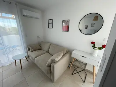 a living room with a couch and a table and a mirror at App. 2 p design zen vue mer N182 in Linguizzetta