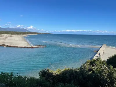 a body of water with a beach and a pier at App. 2 p design zen vue mer N182 in Linguizzetta