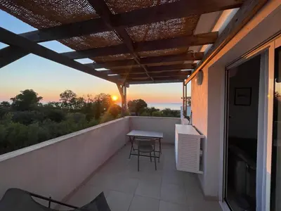 a balcony with a table and chairs and the sunset at App. 2 p design zen vue mer N182 in Linguizzetta