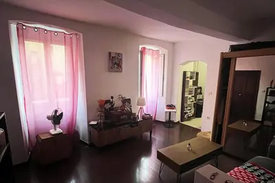 a living room with pink curtains and a couch at Appartement T2 Ajaccio vieille ville in Ajaccio