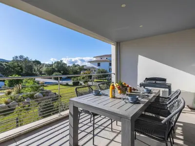 a table and chairs on a balcony with a view at Apartment Domaine d'Arca G7 by Interhome in Porto-Vecchio