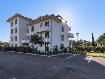 a large white building with a parking lot at Apartment Domaine d'Arca G1 by Interhome in Porto-Vecchio