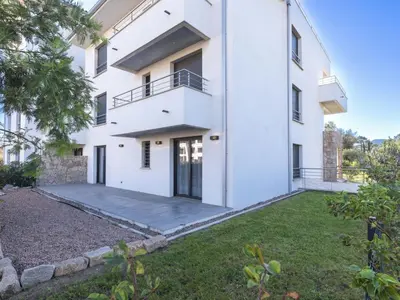 an exterior view of a white building with a yard at Apartment Domaine d'Arca G1 by Interhome in Porto-Vecchio