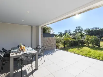 a dining room with a table and chairs on a patio at Apartment Domaine d'Arca G1 by Interhome in Porto-Vecchio