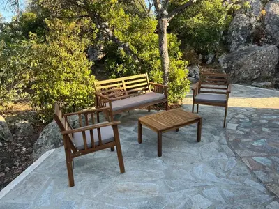 three wooden chairs and a bench on a patio at Maison de vacances dans village AUTHENTIQUE Corse in Bonifacio