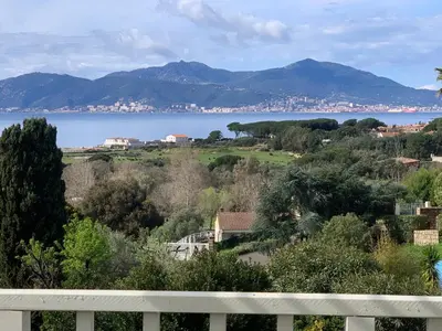 a table with a bottle of wine on a deck at Corsicadream Arone superbe appartement dans villa, vue panoramique mer, piscine, proche Porticcio in Pietrosella