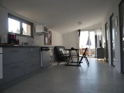 a kitchen with a counter and a table and chairs at Corsicadream Arone superbe appartement dans villa, vue panoramique mer, piscine, proche Porticcio in Pietrosella