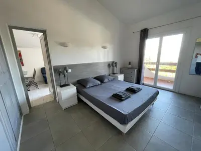 a bedroom with a large bed and a large mirror at Corsicadream Arone superbe appartement dans villa, vue panoramique mer, piscine, proche Porticcio in Pietrosella