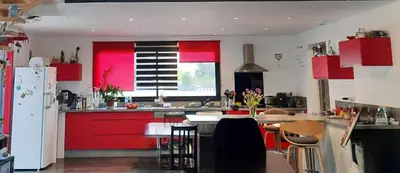 a kitchen with red cabinets and a table with chairs at Chez Cendra in Borgo