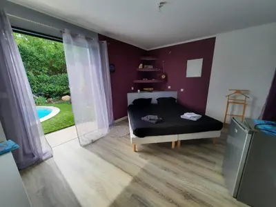 a bedroom with a bed and a large window at Chez Cendra in Borgo