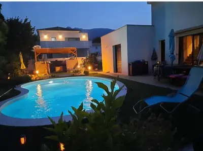 a swimming pool in front of a house at night at Chez Cendra in Borgo