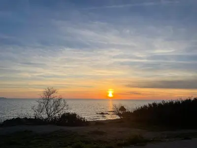 a sunset over the ocean with the sun setting at Villa proche plage extrême sud Corse in Monacia-dʼAullène
