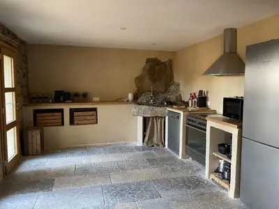 a kitchen with a stove and a refrigerator at Villa proche plage extrême sud Corse in Monacia-dʼAullène