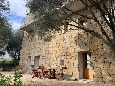 a table and chairs in front of a stone building at Villa proche plage extrême sud Corse in Monacia-dʼAullène