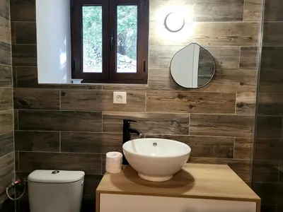 a bathroom with a sink and a toilet and a mirror at L anghjuledda 2 in Grosseto-Prugna