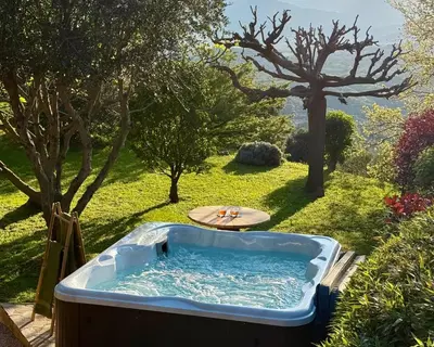 a hot tub in a yard with trees at Carpediem corsica adult only in Poggio-dʼOletta