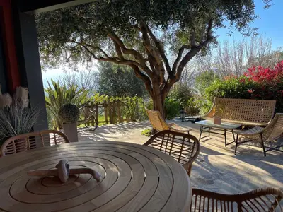 a patio with a table and chairs and a tree at Carpediem corsica adult only in Poggio-dʼOletta