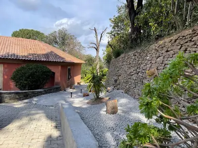 a stone wall next to a house with a courtyard at Carpediem corsica adult only in Poggio-dʼOletta