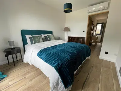 a bedroom with a large bed with a blue blanket at Carpediem corsica adult only in Poggio-dʼOletta