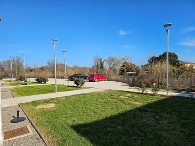 a park with a red car parked in a parking lot at Superbe appartement vue mer terrasse couverte face à la mer in Linguizzetta